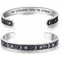 The Solstice Cuff, a silver open cuff engraved with suns, moons, and stars